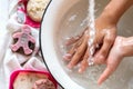 ChildÃ¢â¬â¢s hands under white bowl with water upon water stream Royalty Free Stock Photo